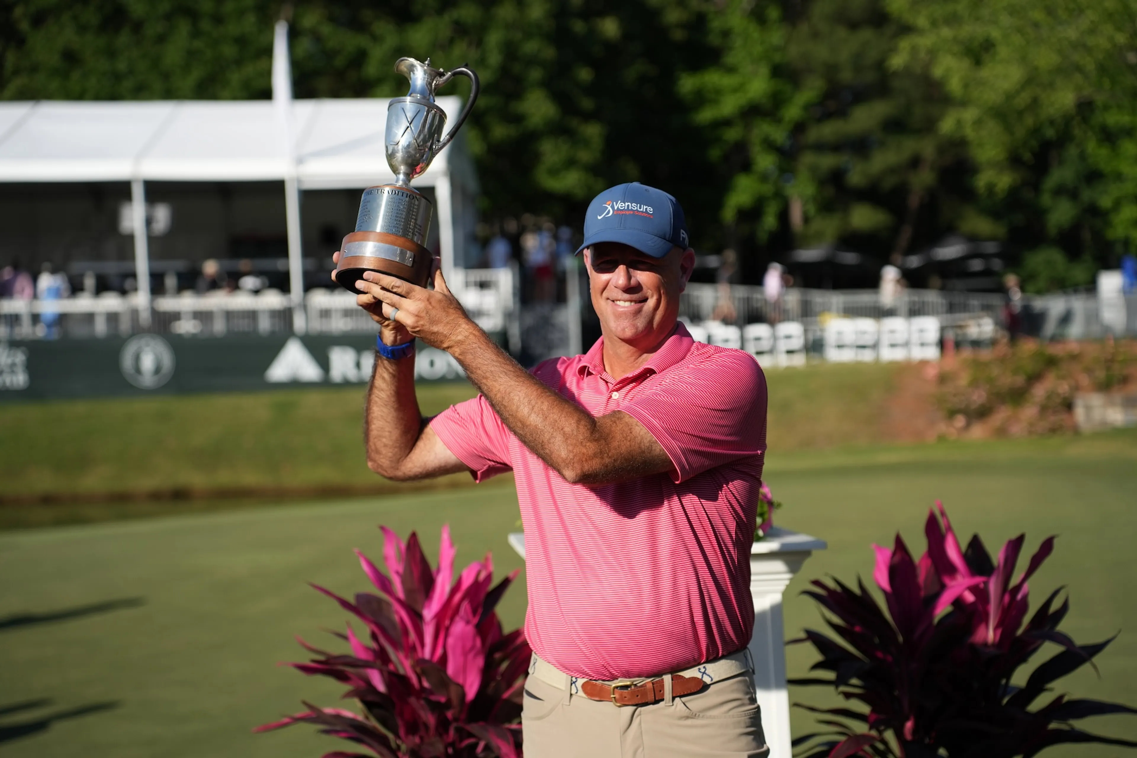 Regions Tradition champion Stewart Cint raising trophy made by Malcolm DeMille